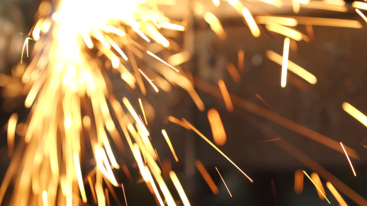 Shiny sparklers of angle grinder in dark room