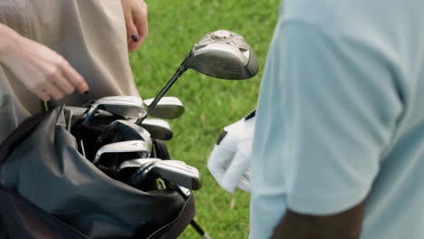 una vista de cerca de las manos del jugador de golf con guantes.