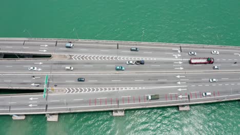 Penang-Bridge-Malaysia-aerial-side-view-with-traffic-lanes-merging-in-both-directions,-drone-bird's-eye-view-tilt-up-shot