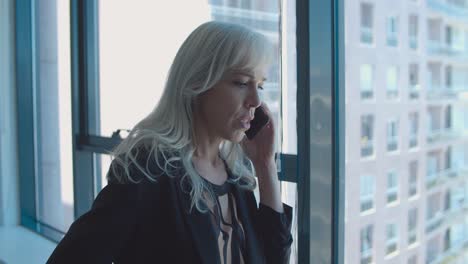 serious middle aged businesswoman standing near window