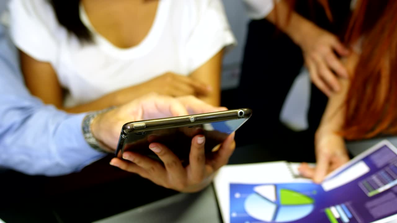 colegas de negocios discutiendo sobre una tableta digital 4k