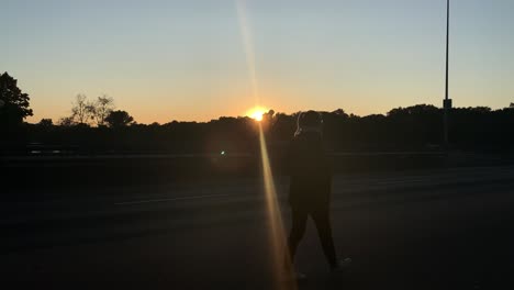 Silueta-De-Mujer-Rubia-Joven-Y-Bonita-Caminando-Por-La-Calle-Frente-Al-Sol-Poniéndose