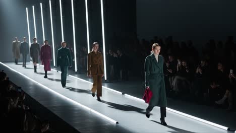a stunning fashion showcase featuring models gracefully walking the runway amidst striking neon lighting and an engaged audience captivated by the latest trends