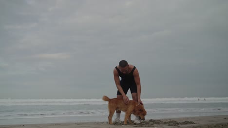 man playing with his dog on a beach