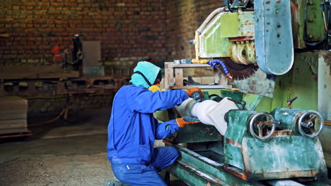 man polishing granite stone. male worker using sanding machine on stone