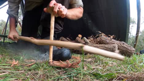 close up shot of a australian bushman creating primative fire with a bow drill