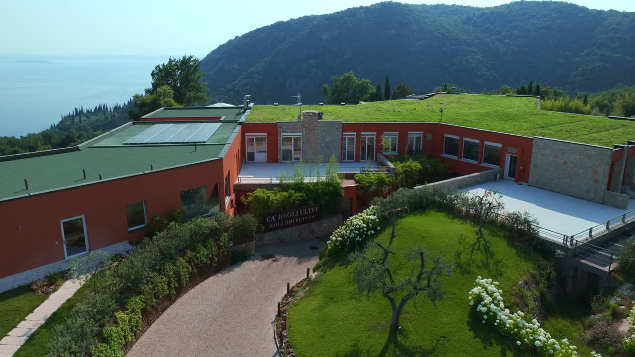 Aerial View Of Entrance To Golf Ca 'Degli Ulivi Located In Marciaga, Italy With Grass Rooftop Along With Solar Panels