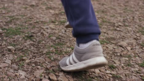 cross country running feet run through rocky terrain,view from behind. feet men running through the stones. loop footage