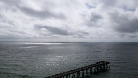 Escena-Relajante---Muelle-Oceánico-Con-Hermosas-Nubes-Sobre-El-Horizonte,-Paisaje-Marino-De-Drones-Aéreos