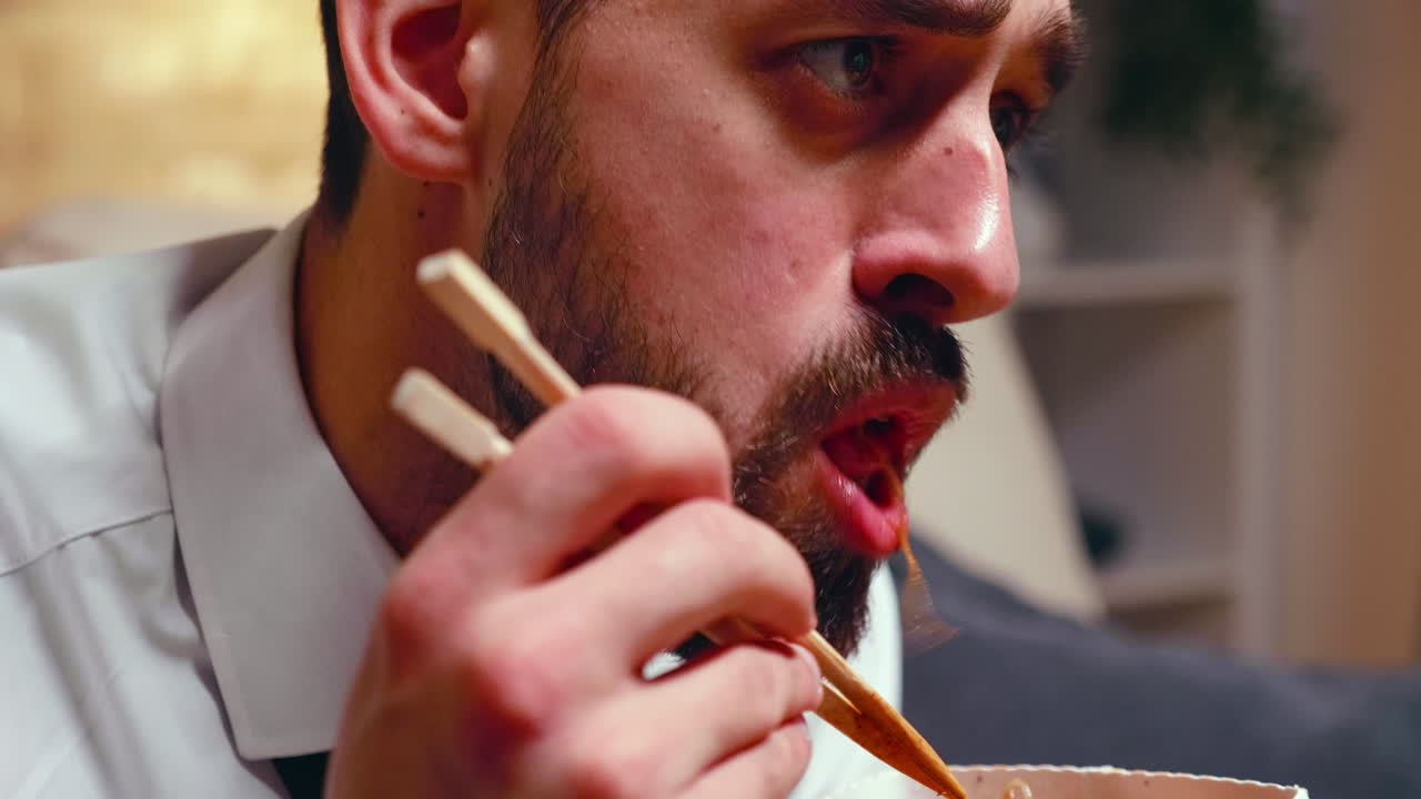 Close up of tired entrepreneur eating noodles