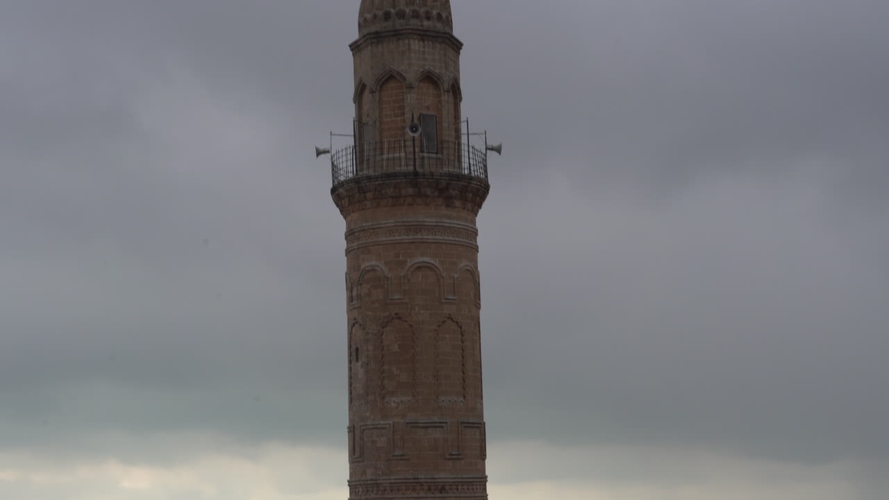 al inclinar la cámara hacia arriba, comenzando desde la cúpula de la mezquita mardin ulu y escaneando el minarete, se ve el balcón del minarete