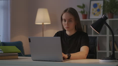 mujer está trabajando con una computadora portátil desde casa por la noche trabajo independiente y remoto por internet escribiendo texto en el teclado enviando mensajes y correos electrónicos retrato medio