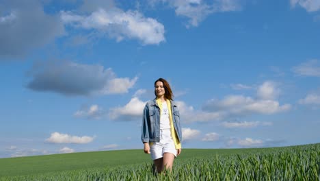 happy free young girl in green wheat happy free young girl in green wheat attractive woman happily walks in a slow motion field touching ears of wheat with her hands woman enjoying nature