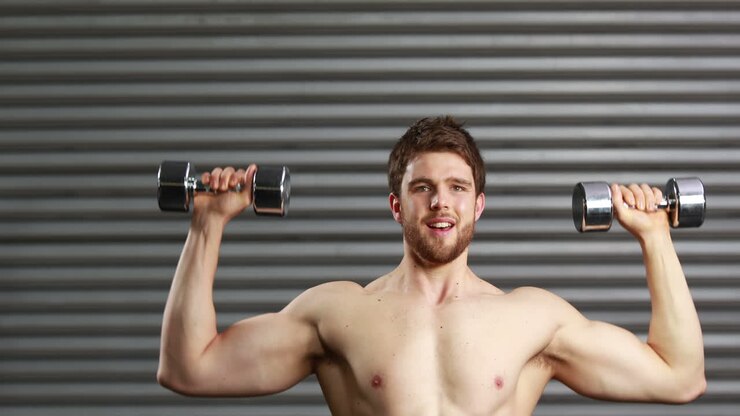 Concentrated man lifting dumbbells