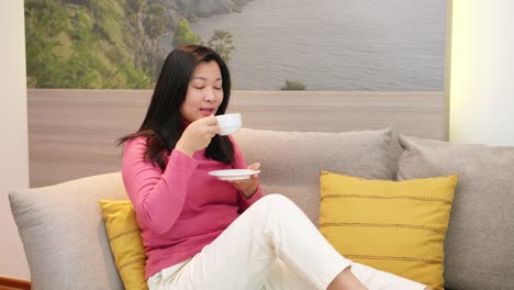 beauty asian women are resting on the sofa and drinking coffee in the morning vacation time