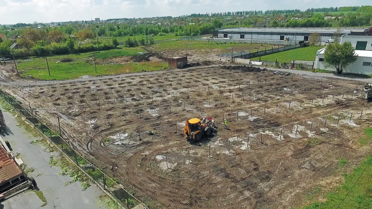 Aerial view of construction. Yellow excavator working on construction site