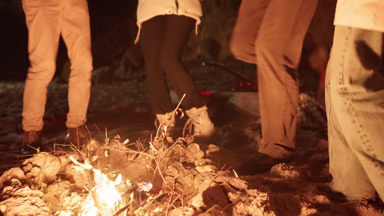 Friends Dancing Around a Campfire at Night