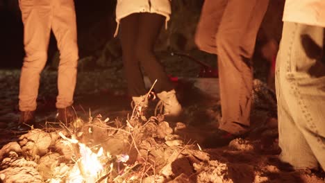 friends dancing around a campfire at night