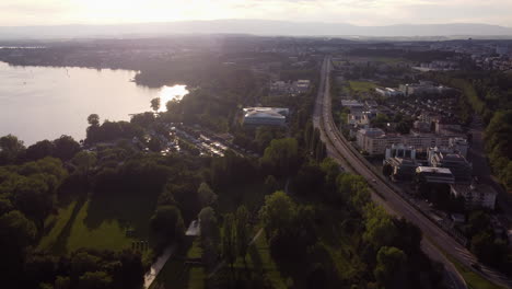 antena lenta sobre lausana, suiza y el edificio del comité olímpico internacional al atardecer