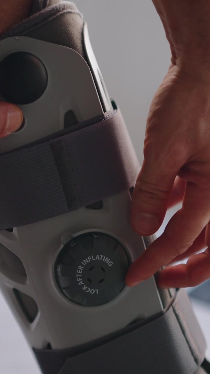 Person Adjusting and Tightening an Orthopedic Leg Brace