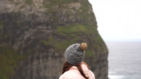 Frau-Wird-Kälter-Und-Besucht-Morro-Do-Castelo-Branco-Mit-Rosa-Jacke-Und-Grauer-Mütze