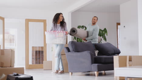 Loving-Couple-Carrying-Boxes-Into-New-Home-On-Moving-Day