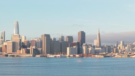 morning fog lifts as the skyline emerges, revealing the full stretch of san francisco’s eastern architectural spine.