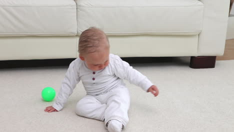 baby playing with a turquoise ball