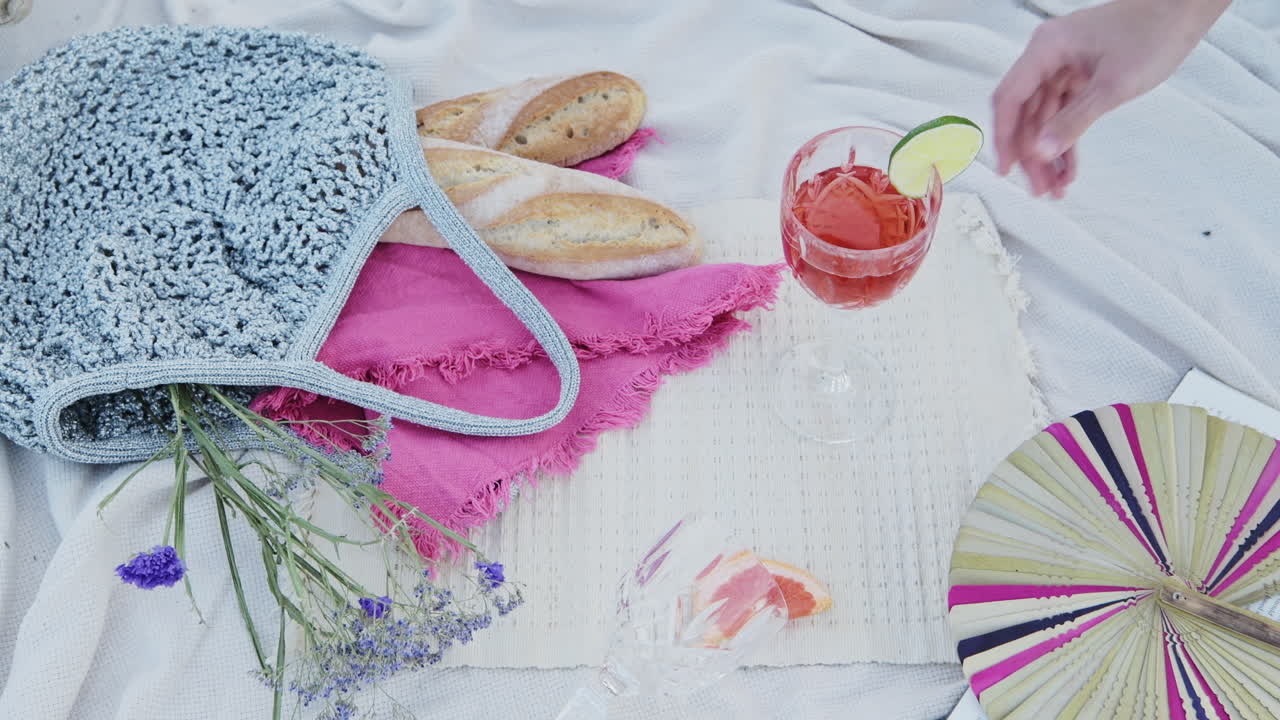A Glass Of Rose Wine in a luxury romantic picnic date on a white blanket at the beach - Close Up Shot