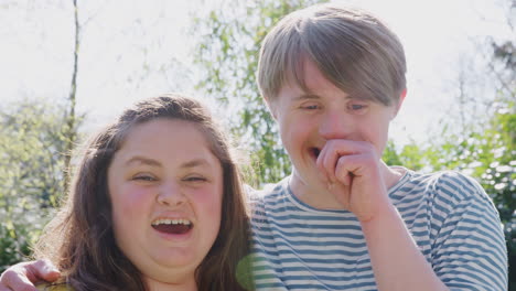 Outdoor-Portrait-Of-Loving-Young-Downs-Syndrome-Couple-In-Garden-At-Home-Together