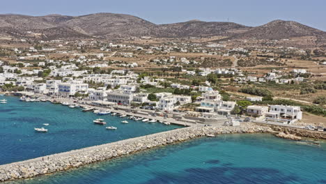 aliki paros grecia antena v1 drone vuela alrededor capturando el exótico mar egeo y el pueblo pesquero frente al mar con edificios encalados sobre un fondo montañoso - septiembre de 2021