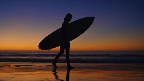 female surfer walking with surfboard in the beach 4k