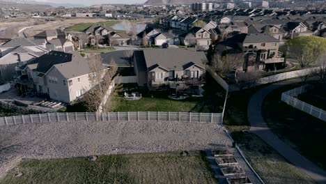 aerial push in view of a home with a comfortable backyard deck and outdoor living space