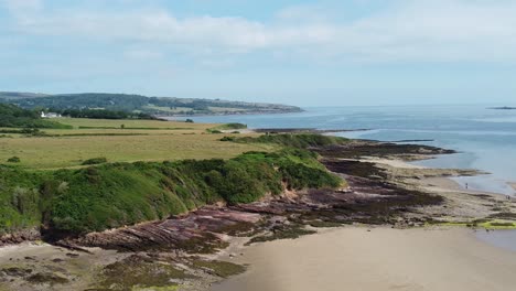 Traeth-Lligwy-Anglesey-aerial-view-over-eroded-coastal-shoreline-and-scenic-green-rolling-Welsh-weathered-coastline