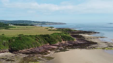 traeth lligwy anglesey aerial view over eroded coastal shoreline and scenic green rolling welsh weathered coastline