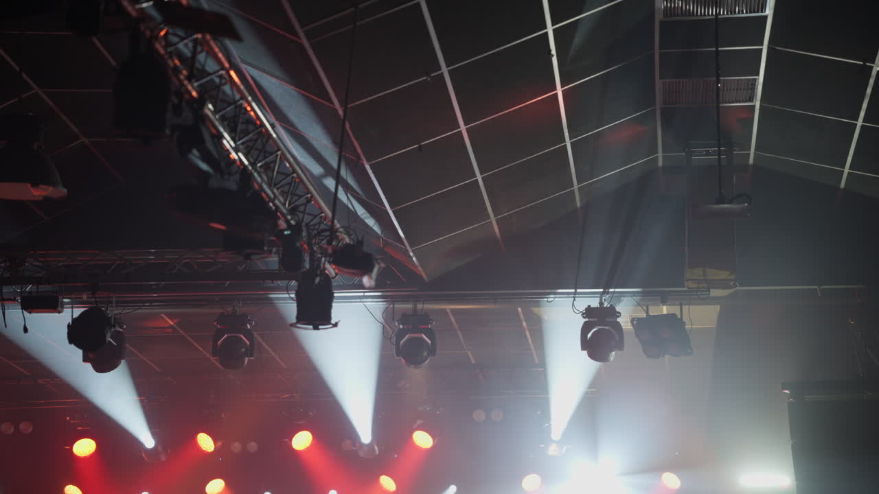 Dynamic Stage Lights Illuminating a Dark Venue with Smoke