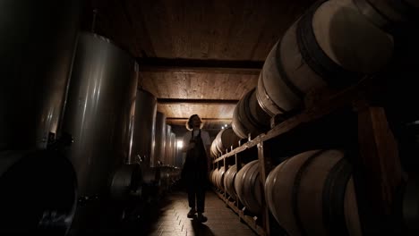la toma auténtica de un sommelier masculino exitoso es degustar un sabor y comprobar la calidad del vino blanco vertido en vidrio transparente en una bodega de vino.