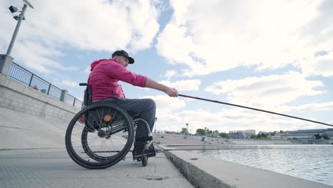 person with a physical disability who uses wheelchair fishing from fishing pier