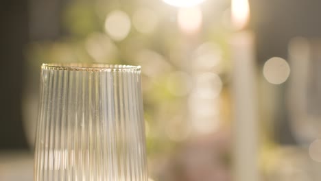 close up of gold rimmed glass on table set for meal at wedding reception 1