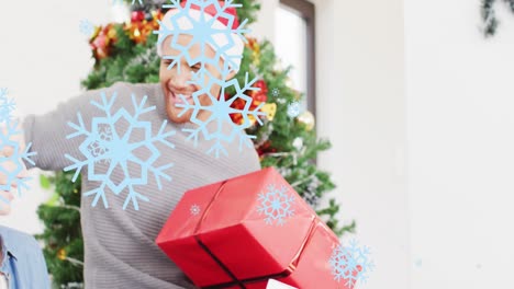 animación de copos de nieve de navidad sobre hombre caucásico en sombrero de santa en navidad con regalos.