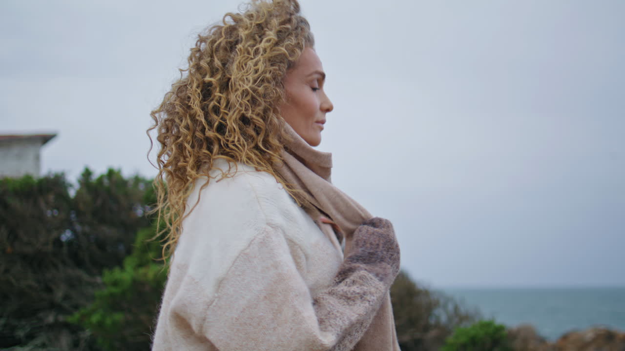 mujer soñadora contemplando el paisaje marítimo ventoso en vacaciones de cerca. dama romántica