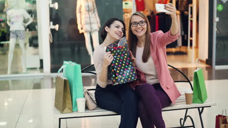 Two women friends taking a selfie in a shopping mall