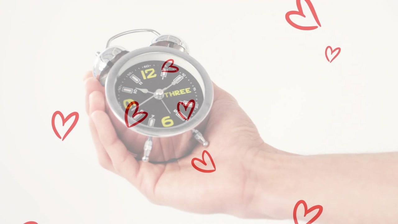 Hand entering from right holding silver clock causing red hearts rising drifting highlighting clock