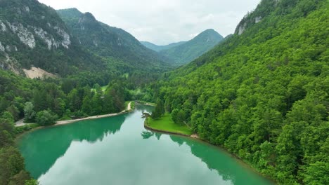 Luftdrohnenaufnahme-Einer-Türkisfarbenen-Seenlandschaft-Und-Grünen-Hügeln-In-Završnica,-Slowenien,-Reisen-Und-Tourismus,-Natürliches-Panorama-In-Zeitlupe