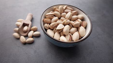pistachos en un tazón con una cuchara de madera
