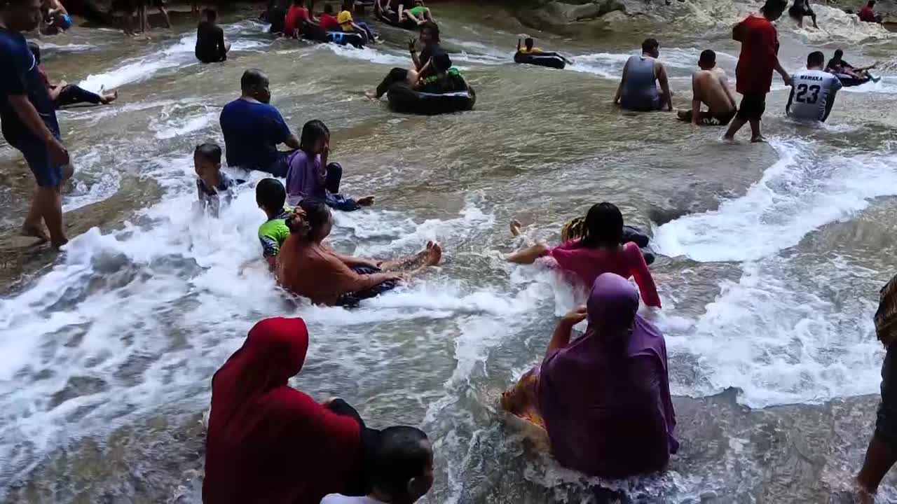 Tourist in front of the Bantimurung waterfall in Maros, South Sulawesi. slow motion.