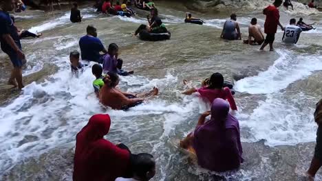 tourist in front of the bantimurung waterfall in maros, south sulawesi. slow motion.