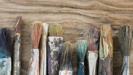 animation of row of used paintbrushes on wooden surface