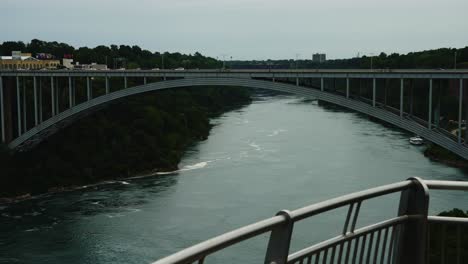 a steady shot of the rainbow bridge stretching across the niagara river, connecting the u.s. and canada under an overcast sky