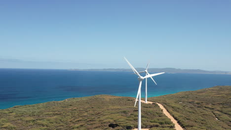 aerial view around turbines in a wind park, on the shoreline of albany, australia - orbit, drone shot